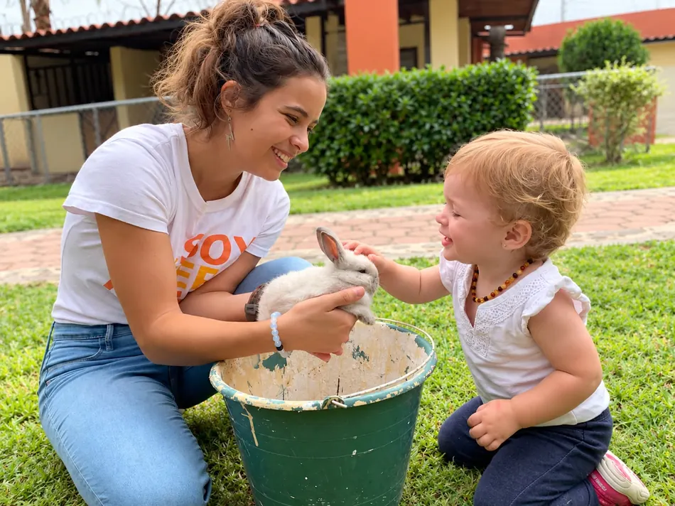 Niñera Kurowi mostrándole un conejo a una niña pequeña