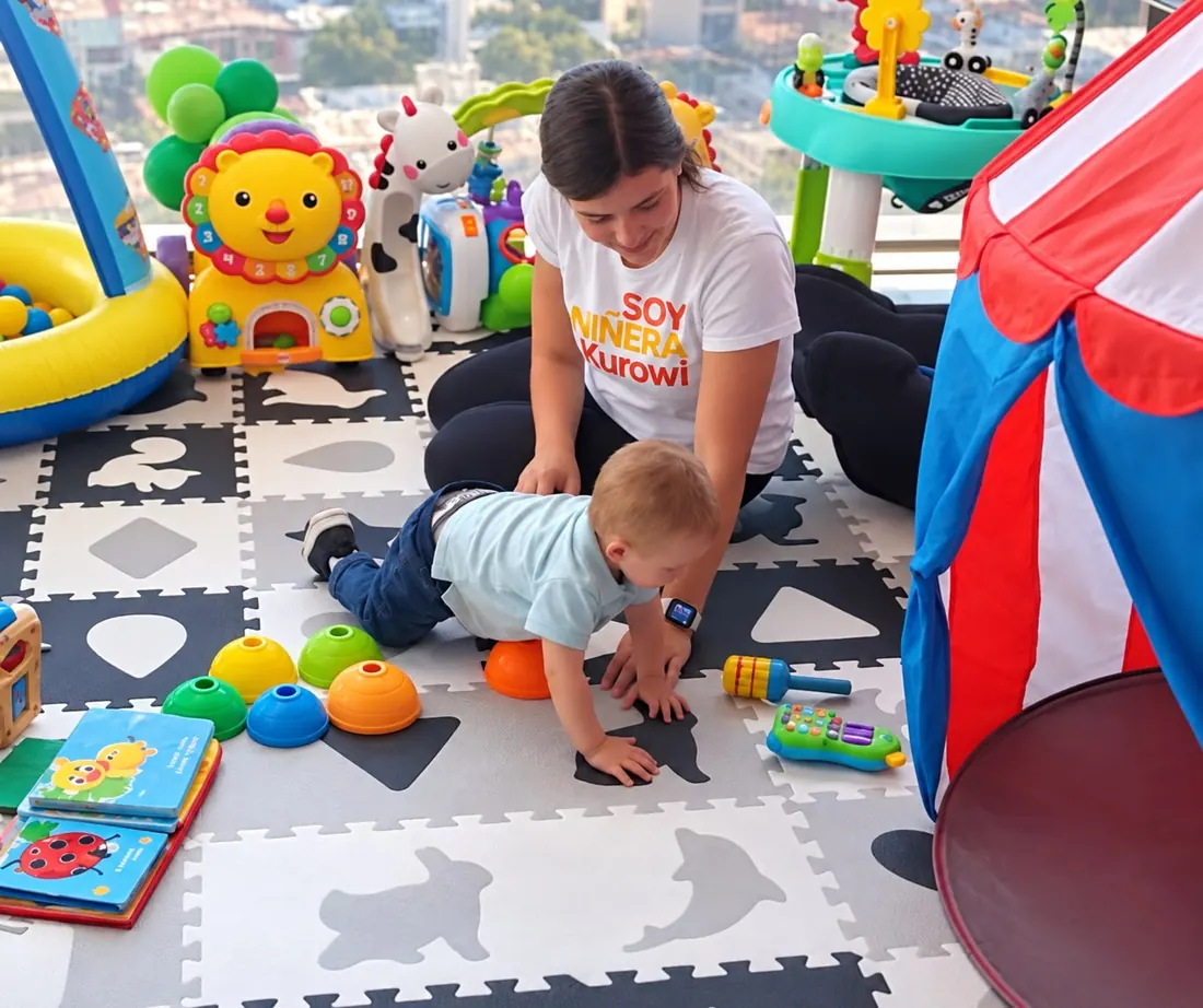 Niñera Kurowi jugando con un bebé en el cuarto de juegos