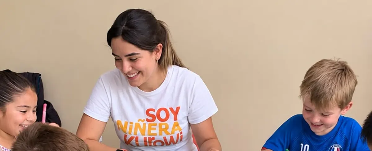 Niñera Kurowi con cinco niños coloreando en el aula de un colegio